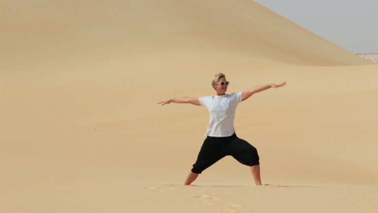 Reise durch Ägypten: Nina Raem in der Wüste in Siwa in der Yogastellung "Krieger 2"