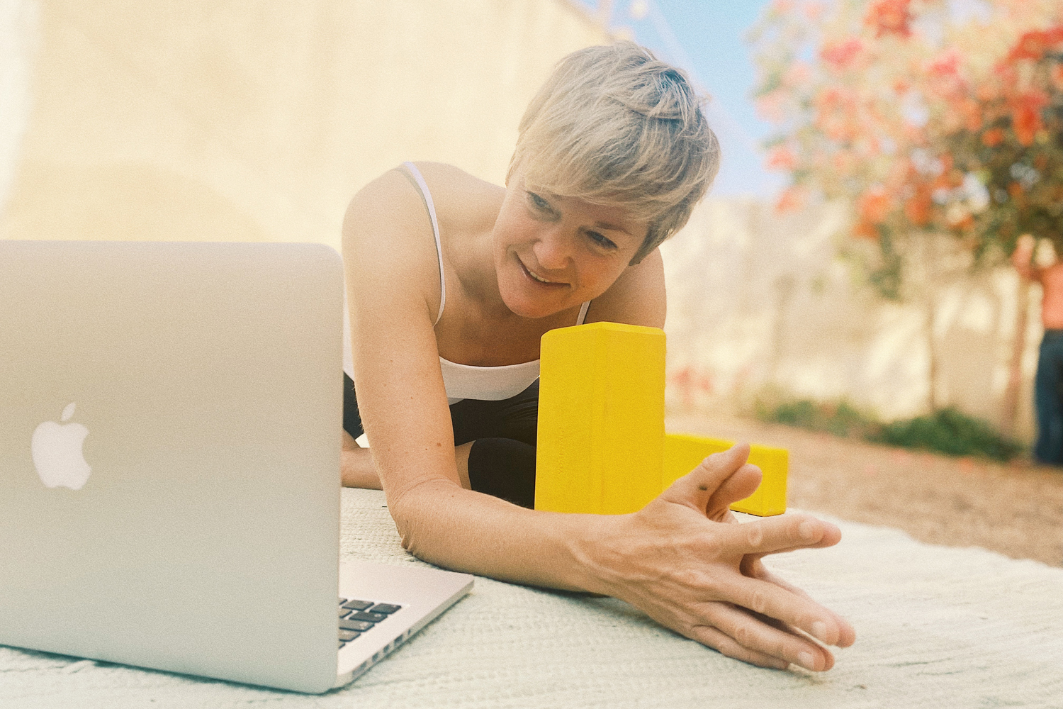 Nina Raem in der Yogastellung "die Taube" vor dem Computer Yoga übend 