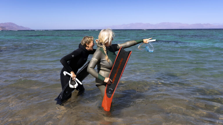 Michèle und Nina, Initiatoren des Projektes THE BLUE PAUSE im Roten Meer auf dem Weg ins Wasser in Eel Garden für einen Fundive