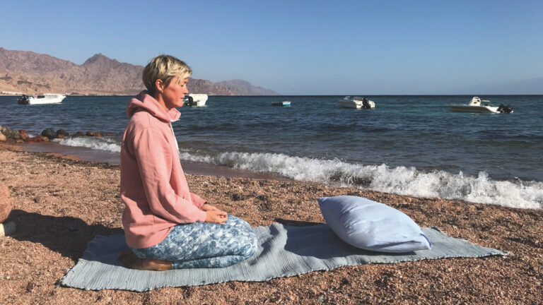 Yin Yoga in Dahab: Nina Raem am Roten Meer im Fersensitz sitzend